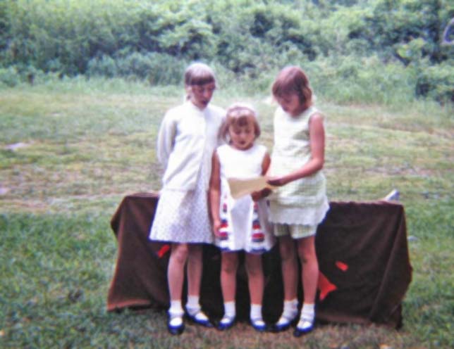 1969 - Barb Konopacki, Julie Henriksen, Elizabeth Sandlin. Singing 'Fathers, Fathers' song during skit program intro. Father's Day skit program at Sandlin cabin.